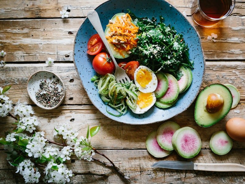 Whole-food bowl with leafy greens, watermelon radish and avocado — nutritional foundations of digestive care