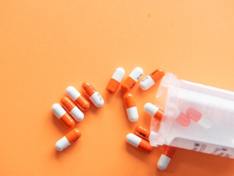 Vitamin capsules in two-tone orange and white — high-dose nutrient and vitamin therapy