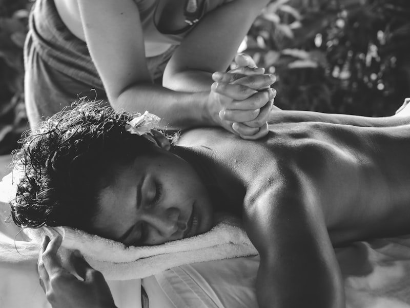 Black-and-white image of hands-on therapy work — manual therapy for chronic pain and headache protocols